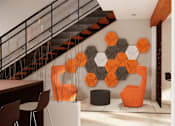 Thumbnail 2 of 13 - A modern living room with a staircase and a large orange and black geometric wall art.