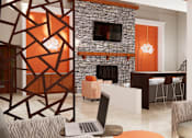 Thumbnail 11 of 13 - A modern living room with a stone fireplace and a laptop on the coffee table.