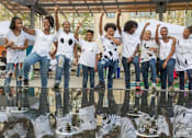 Thumbnail 1 of 6 - A group of people are standing on a reflective surface.