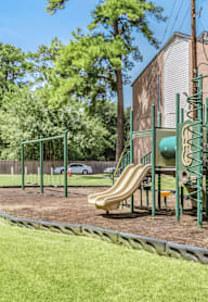 A playground with a green slide and a yellow slide.