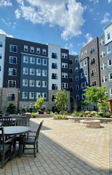 A courtyard with a table and chairs surrounded by apartment buildings.
