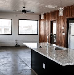 A kitchen with a black counter top and a refrigerator.