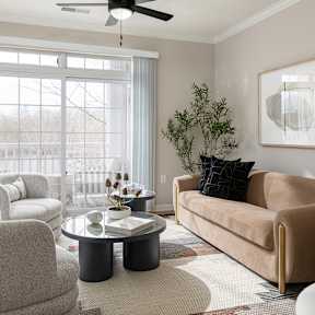 a dining room with a table and chairs and a kitchen with a microwave and a