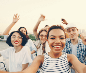 A group of people are standing on a rooftop with their arms raised.