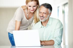 a man and a woman looking at a laptop computer