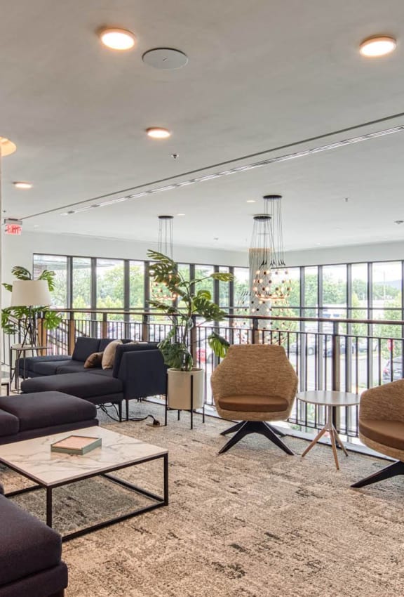 a living room with couches and chairs and a balcony