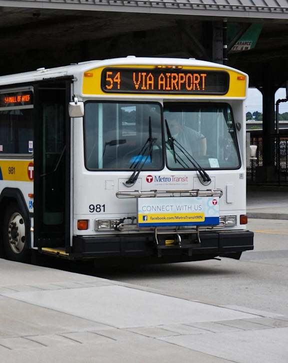 a city bus parked at a bus stop next to another bus