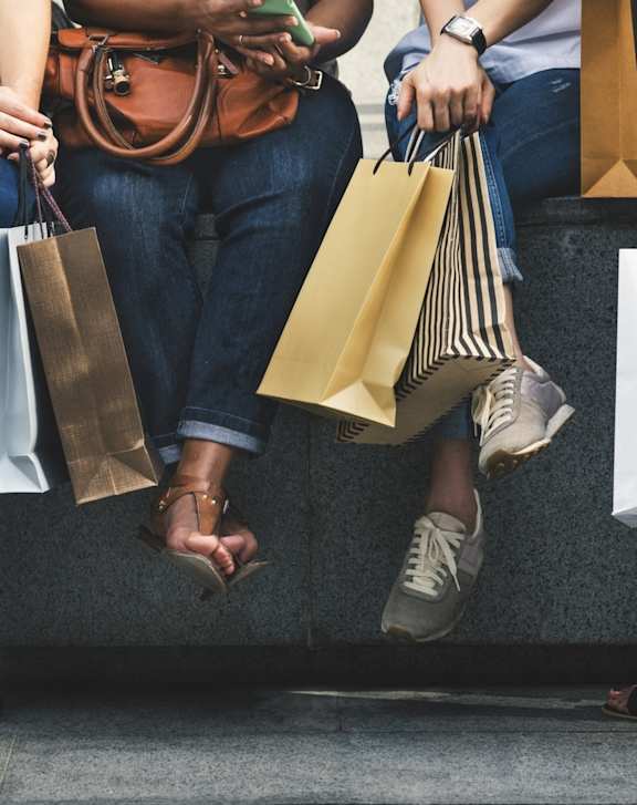 People Sitting on Bench Holding Shopping Bags