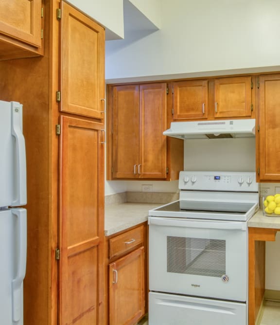 a kitchen with wooden cabinets and white appliances and a sink at North Market South Carroll, Frederick, 21701