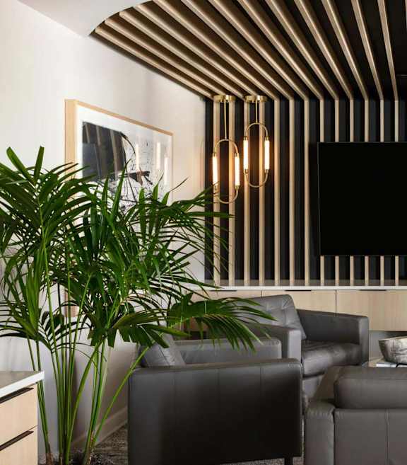 a living room with couches and a tv on the wall at Esplanade District Apartments, Little Rock
