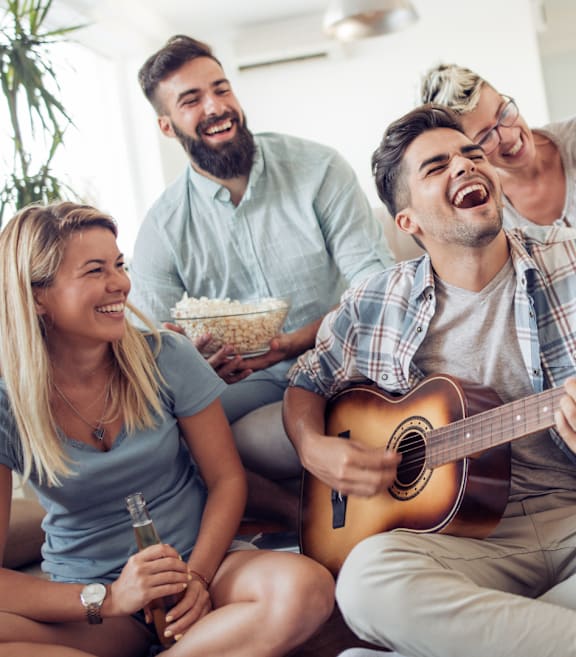 A group of friends are sitting on a couch, laughing and enjoying a night in.
