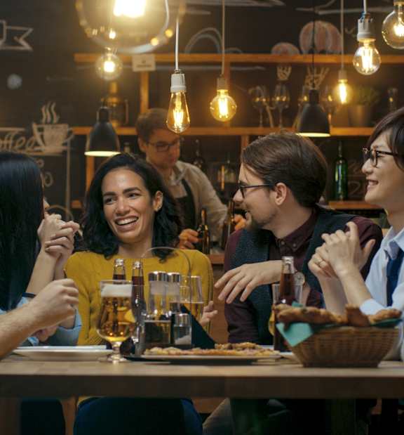 A group of people are sitting around a table in a restaurant.