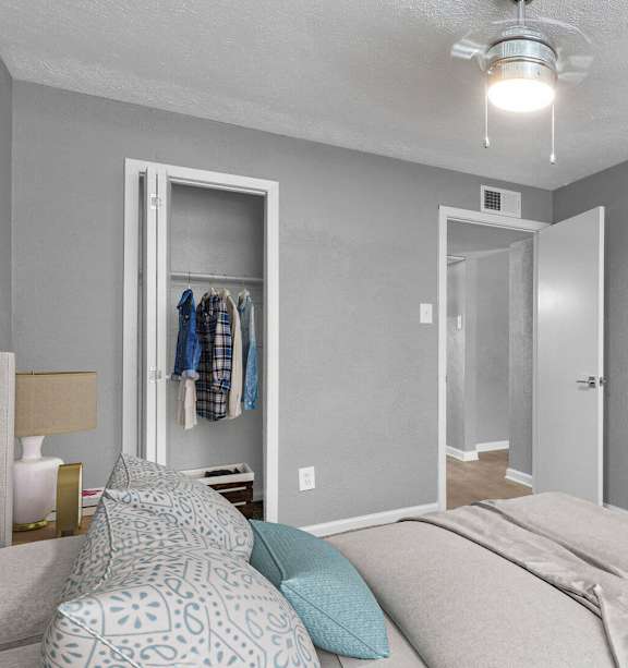 a bedroom with a large bed and a mirror at 46Eleven Apartments, Dallas, TX, 75228