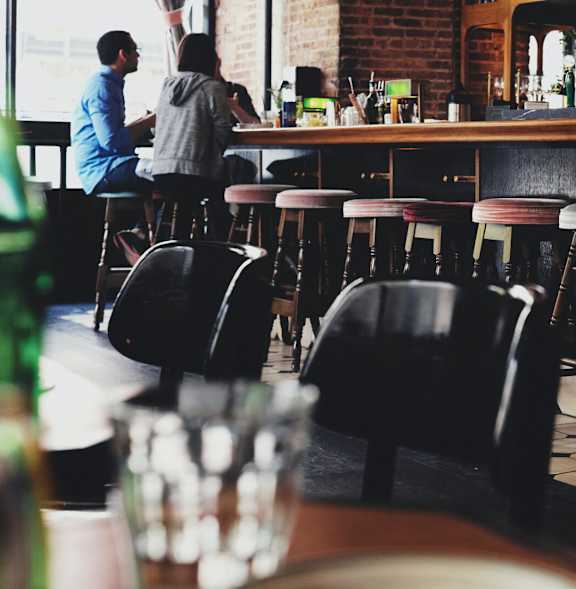 people sitting at a bar in a restaurant with bar stools