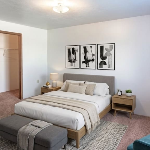 A bedroom with a large bed, a bench, and a chair.