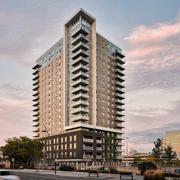 A tall building with a zigzag pattern on the side is the main focus of the image.