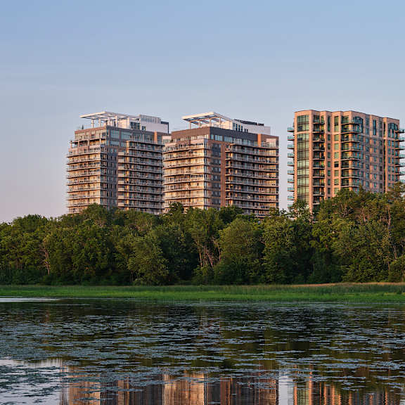 Two buildings are reflected in the water.