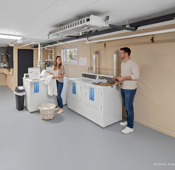 A man and woman are standing in a room with a large white machine.