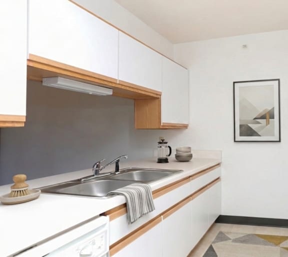 A kitchen with white cabinets and a fridge.