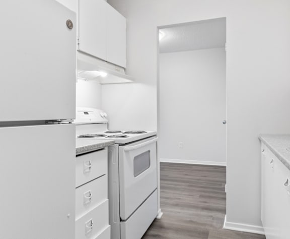 A kitchen with white appliances and cabinets.