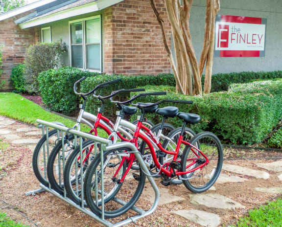 a row of red bikes parked in front of a building