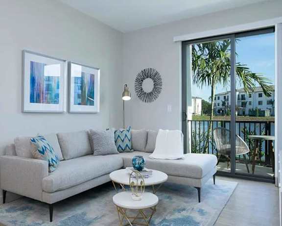 a living room with a couch and a door to a balcony