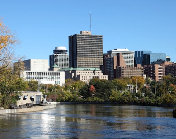 A city skyline with a river in the foreground.