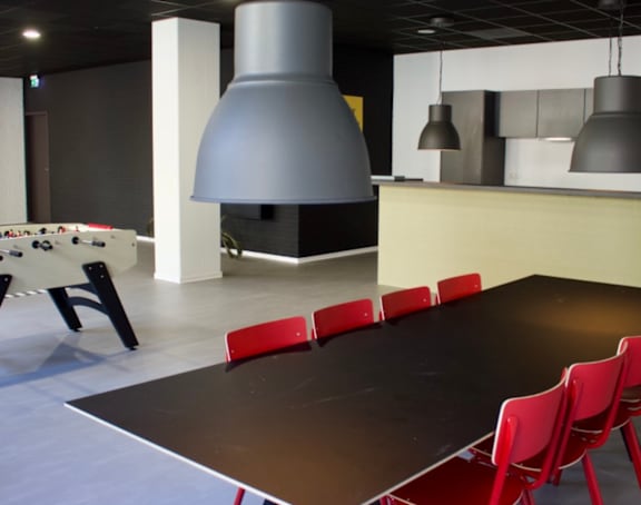 A room with a pool table, a bar, and a billiards table.