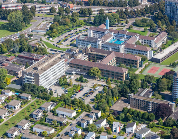 an aerial view of a tall building next to a river