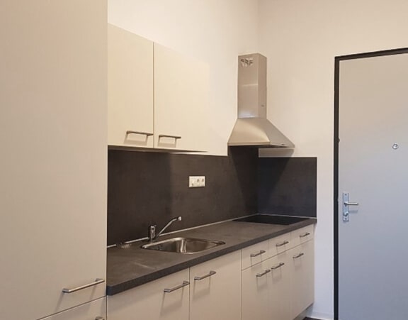 a small kitchen with white cabinets and a sink