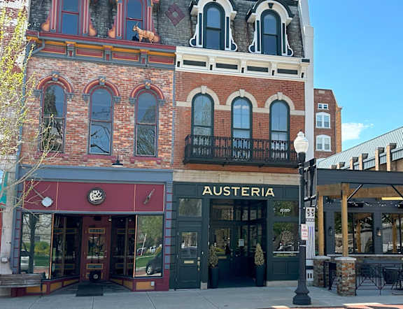 A street view of a building with a sign that says "Austeria".