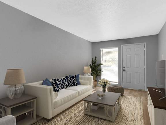 a living room with a beige couch and a mirror at 46Eleven Apartments, Dallas, TX, 75228