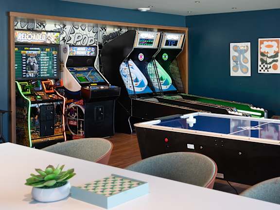 Game room with arcade games at The Bosk Apartment Homes, Minnesota