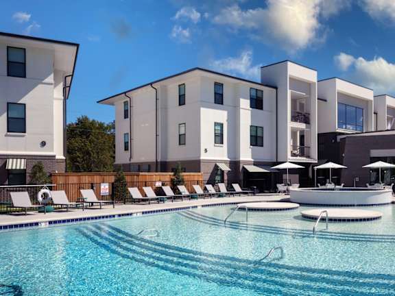 a swimming pool at night with a sunset in the background at Esplanade District Apartments, Little Rock