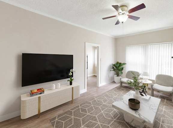 A living room with a television, a couch, a chair, a table, and a plant.