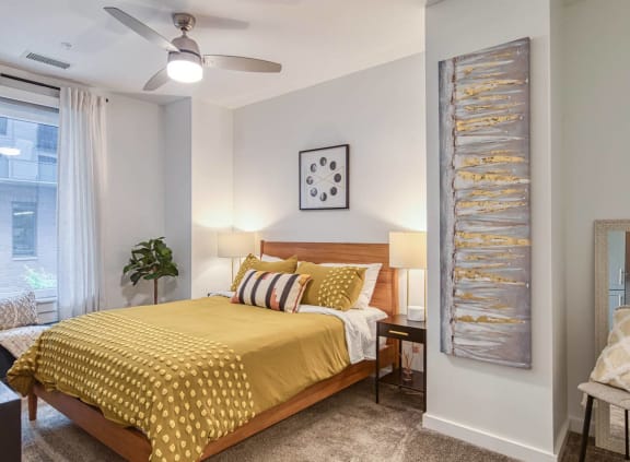 a bedroom with a yellow bed and a ceiling fan