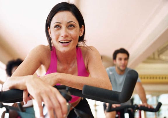 a woman riding an exercise bike in a gym