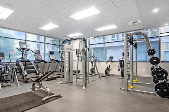 A well-equipped gym with various exercise machines and weights.