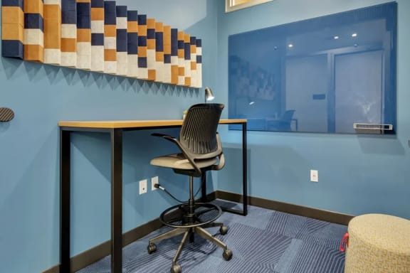 a desk with a chair in a room with a window