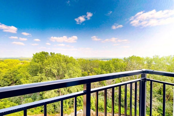 a balcony with a view of trees and a blue sky at Ardor on the Bluffs South Loop Residences Apartments, Bloomington, 55425