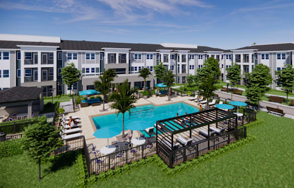 A large swimming pool surrounded by a fence and chairs is in the foreground of a residential area.