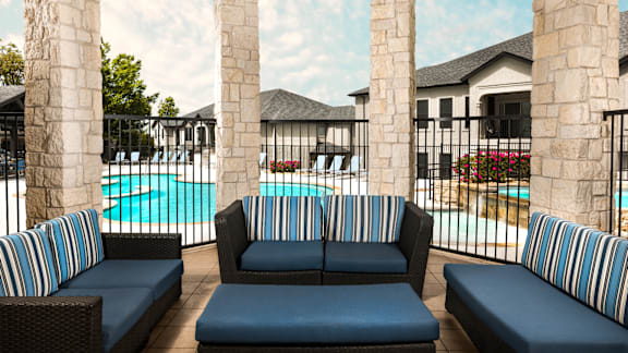 A poolside seating area with blue cushioned sofas and chairs.