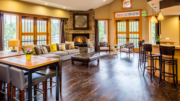 A large, well-lit living room with a fireplace and a dining table.