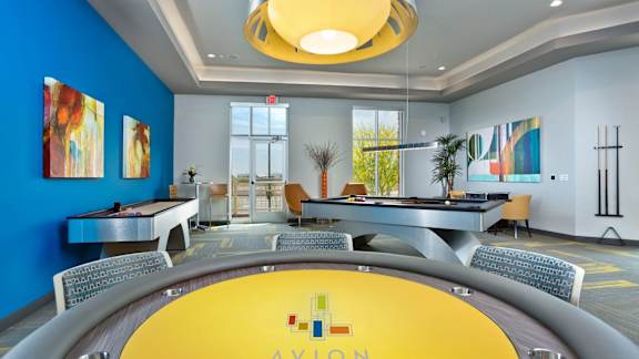 A yellow table with the word "AYON" on it is in the center of a room with blue walls.