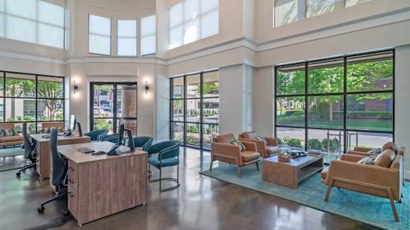 A spacious office with a view of the outdoors through large windows.