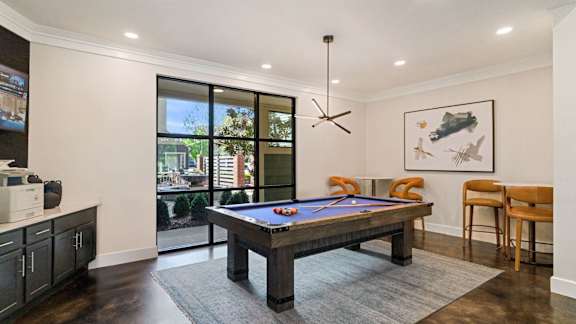 A room with a pool table and a chair.