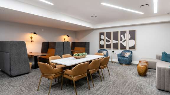 A modern dining room with a large table and chairs.