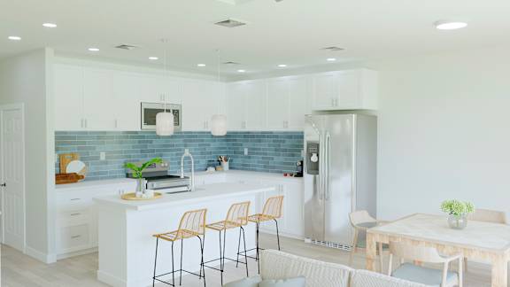 A kitchen with a blue backsplash and white cabinets.