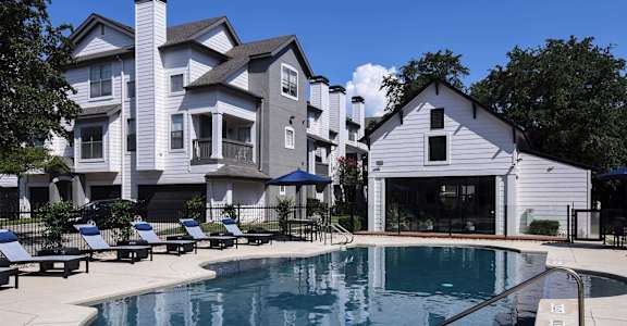 A large white house with a pool in front.