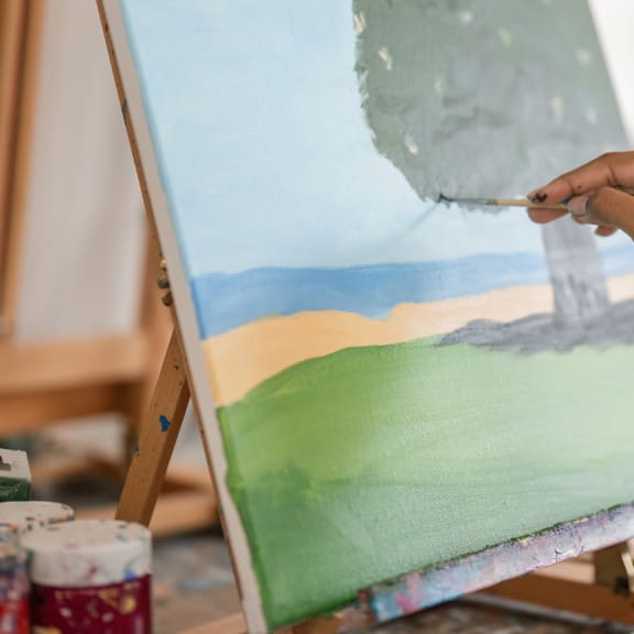 a person working on a painting with a paint brush